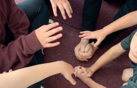 Photogrpah of lots of children's hands in a circle
