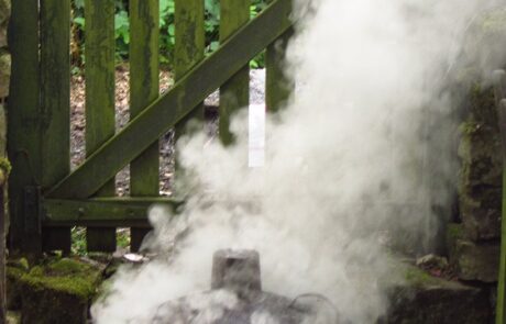 Photograph of raku kiln outside with smoke coming out of it