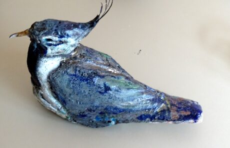 Photograph of a ceramic lapwing with iridescent glaze