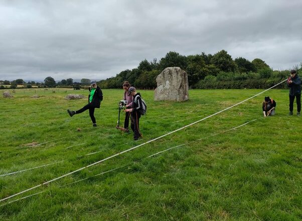 The image shows a group of students in a field with