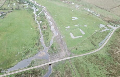 Aerial photograph of re-wiggled beck with track crossing it and line of old straight beck course