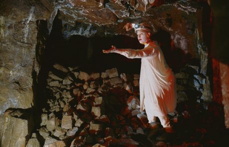 Photograph of person standing on rocks inside a mine tunnel