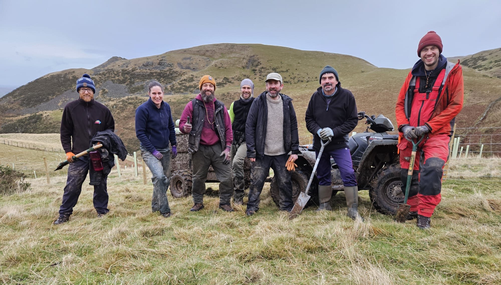 Staff from North Pennines National Landscape and contractors in Ousby. One staff member with a spade.