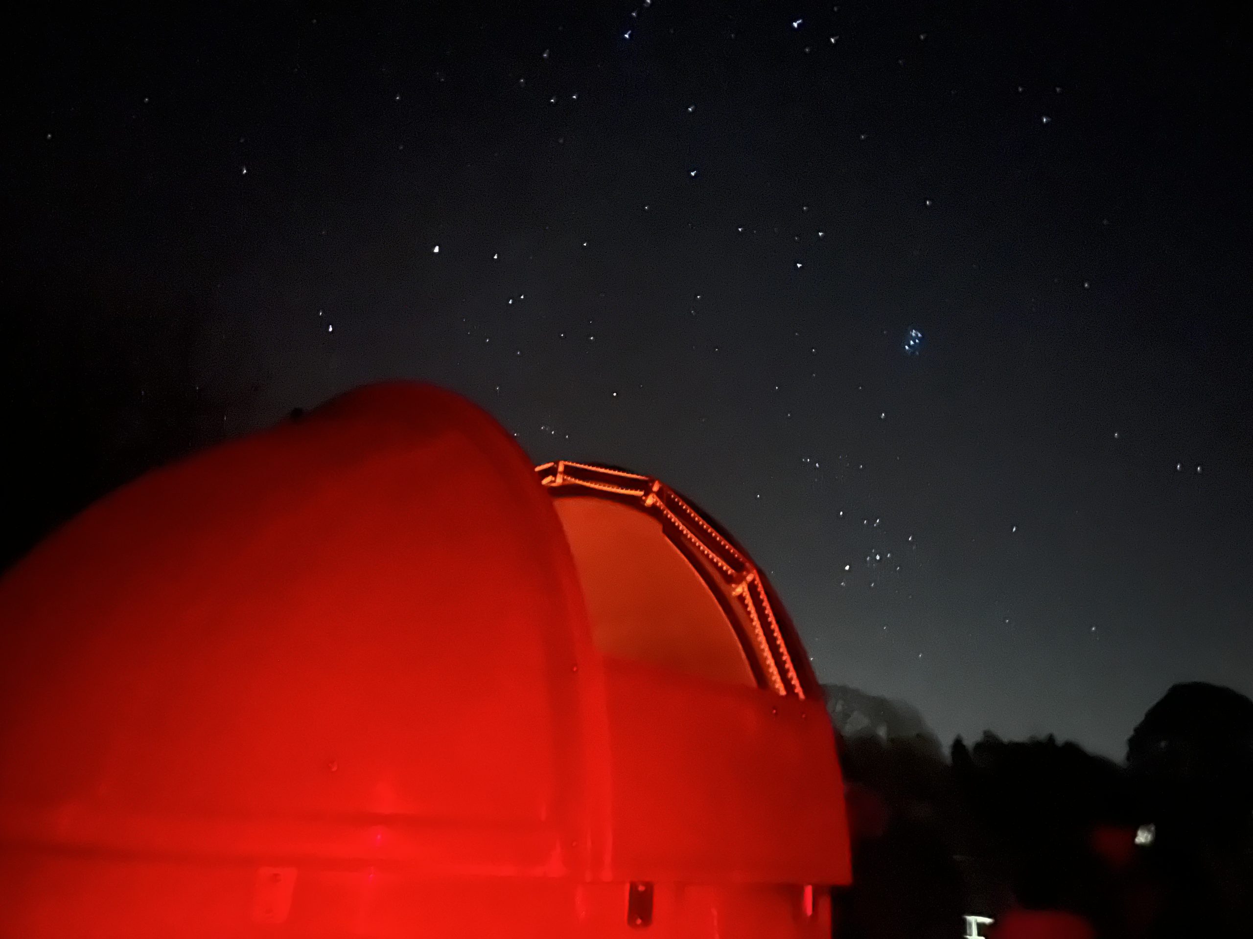 Alston Moor Observatory in red light. Dark sky with stars.