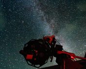 Large telescope at Grassholme Observatory in foreground. The telescope is facing up to a starry dark sky in the North Pennines.