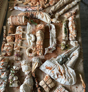 Photograph of bundles of cloth ties with string on a table