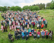 Group of people sitting and standing in a field for the Alston Moor community mass photo 2026